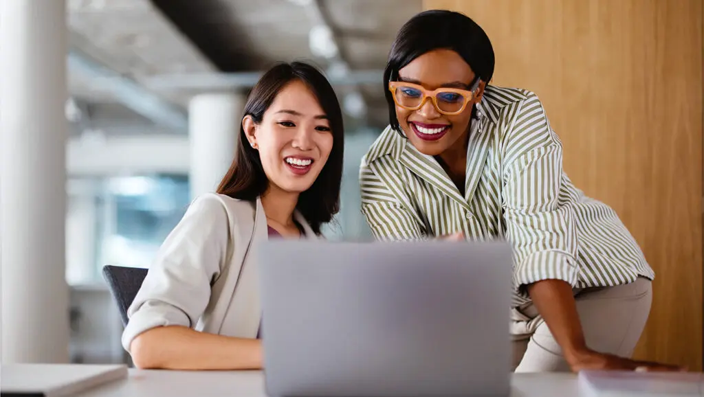 A picture of two nonprofit professionals taking the CCS Philanthropy Pulse Survey on a laptop.