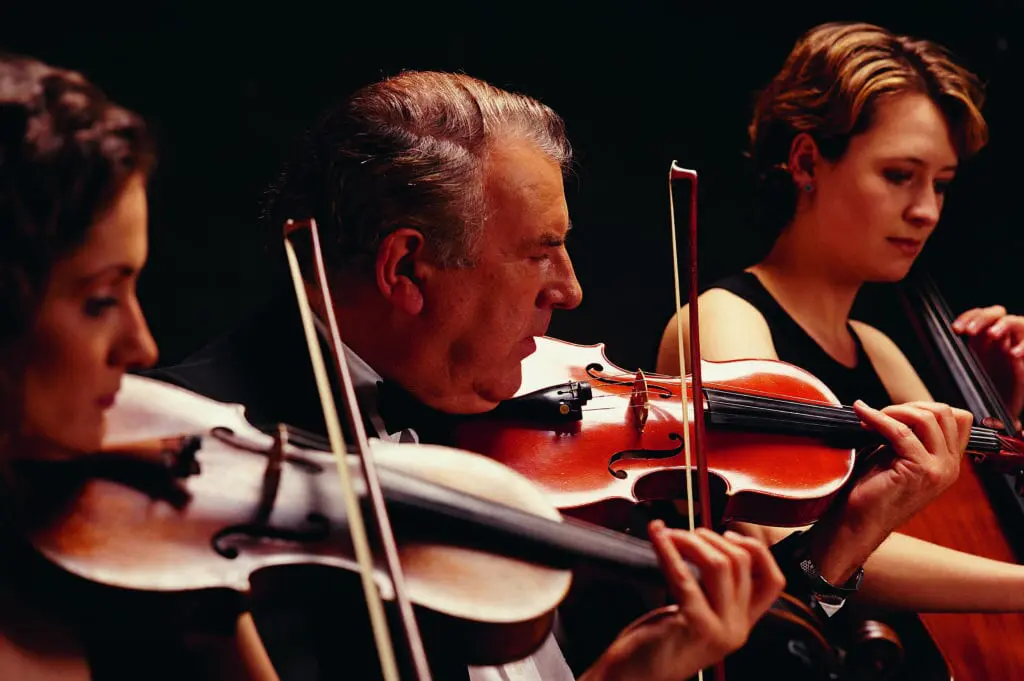 A picture of three violinists playing.